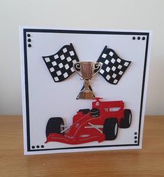 a close up of a card with a race car and a trophy on it's side