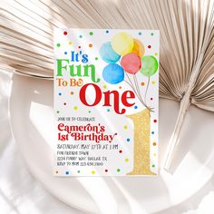 a first birthday party card with balloons and confetti on the front, it's fun to be one