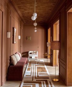 the hallway is lined with wooden paneling and pink walls