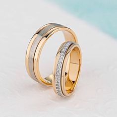 two gold wedding bands with white diamonds on each band, set in 18k yellow and white gold