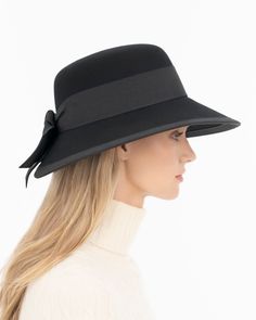 A women’s fall felt hat, trimmed with grosgrain that is timeless and chic. This is a special occasion style, not to be worn casually, which adds grace and presence. Viewed from the front, the dressy silhouette reminds one of Audrey Hepburn’s hats; a medium size brim curves gently downward .The unexpected surprise feature is the cutaway tulip shape of the brim in back, which finishes in a feminine double bow. UPF 50+ Blocks 98% UVA/UVB rays Hand blocked Elasticized inner band for comfortable fit Classic Wide Brim Felt Hat For Evening, Chic Cloche Hat With Short Brim, Formal Brimmed Felt Hat For Spring, Spring Formal Brimmed Felt Hat, Chic Evening Fedora Hat, Formal Wide Brim Cloche Hat For Fall, Elegant Wide Brim Hat For Fall, Chic Wide Brim Felt Hat For Kentucky Derby, Luxury Retro Hat With Curved Brim