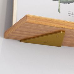 a close up of a wooden shelf with a plant on it