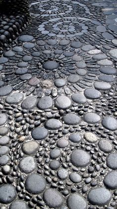 a cobblestone street is shown with water running between it and rocks on the ground