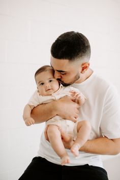 a man holding a baby in his arms