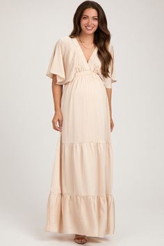 Beige V-Neck Flutter Sleeve Tiered Maternity Maxi Dress Flowy Maxi-length Maternity Dress For Beach, Flowy Maternity Maxi Dress For Beach, Flowy Maxi Length Maternity Dress For The Beach, Flowy Maxi Maternity Dress For The Beach, Chic Flowy V-neck Maternity Dress, Feminine Ruffled Maxi Dress With Surplice Neckline, Feminine Maxi Dress With Ruffles And Surplice Neckline, Elegant Maxi Length Maternity Dress For Beach, Elegant Maxi Maternity Dress For Beach