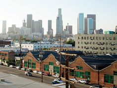 the city skyline is in the distance as cars are parked on the street