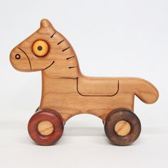 a wooden toy horse with wheels on a white background and an orange eye in the center