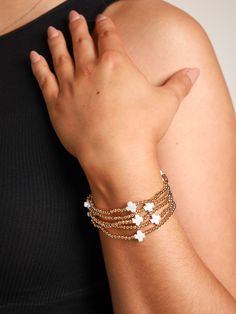 Model is wearing a gold bracelet set with white cross detail. Chic White Beaded Bracelets, Chic White Beaded Bracelet, Admire From Afar, Gold Beaded Bracelet, Beach Color, White Cross, Short Denim Skirt, Gold Bead Bracelets, White Crosses