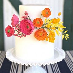 a white cake with flowers on it sitting on a table