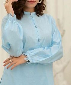 a woman in a blue dress posing for the camera with her hand on her head