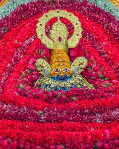 an elaborately decorated statue in the middle of flowers