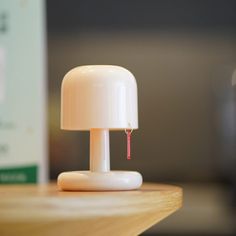 a white lamp sitting on top of a wooden table