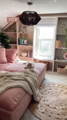 a bedroom with pink bedding and bookshelves