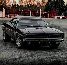 a black muscle car parked in a parking lot