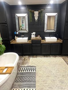 a large bathroom with two sinks, mirrors and a rug in front of the bathtub