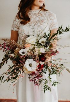 a woman holding a bouquet of flowers in her hands