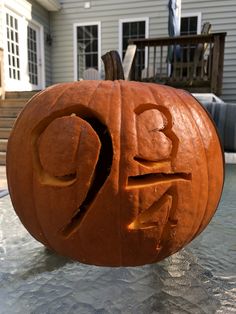 a carved pumpkin with the word boo written on it's face in front of a house