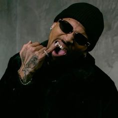 a man with his mouth open wearing sunglasses and a beanie on top of his head