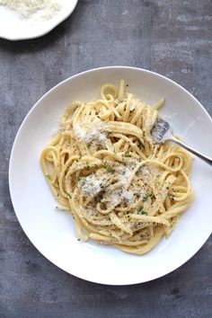 a plate of pasta with parmesan cheese on top