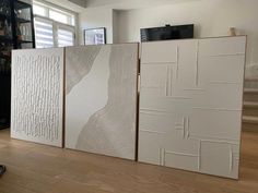 three panels with white paint on them in a living room