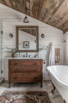 a bathroom with a sink, mirror and bathtub in the middle of the room