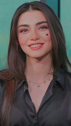 a woman with long hair and piercings on her nose smiles at the camera while wearing a black shirt