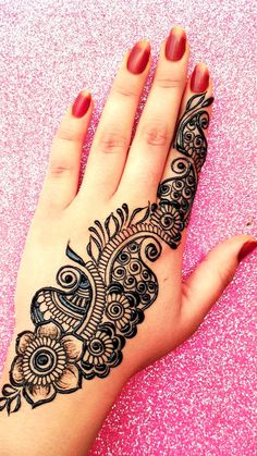 a woman's hand with henna tattoos on it