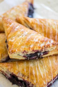 blueberry turnovers with icing sitting on top of each other