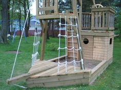 a wooden pirate ship playset in the grass with stairs and ladders on it