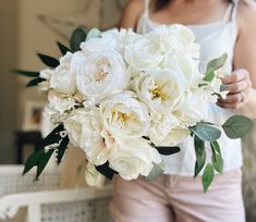 a woman holding a bouquet of white flowers