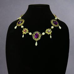 Handcrafted replica period jewelry, made to imitate the style and grandeur of the Tudors. This elegant necklace will complement any renaissance garb, and elevate even the most simple gown into a piece fit for a queen. It is made to order in your choice of gold, silver, or bronze and can be set with resin gemstones of just about any color. Ruby, emerald, sapphire, amethyst and onyx are most popular options. The Margaret Tudor has alternating gemstone settings connected by a single pearl sandwiched between metal bead caps. Each setting is accented with a beautiful dangly teardrop pearl. Baroque Historical Jewelry For Formal Occasions, Baroque Jewelry With Historical Design For Formal Occasions, Baroque Historical Design Jewelry For Formal Occasions, Elegant Baroque Necklace With Historical Design, Ornate Historical Design Necklaces For Formal Occasions, Ornate Historical Design Necklace For Formal Occasions, Baroque Necklace With Historical Design As A Gift, Baroque Historical Design Necklace For Gift, Baroque Necklace With Historical Design For Weddings