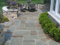 an outdoor patio with stone walls and seating area