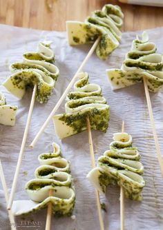 pesto and cheese skewers on a sheet of parchment paper with text overlay that reads, puff pastry pesto christmas trees