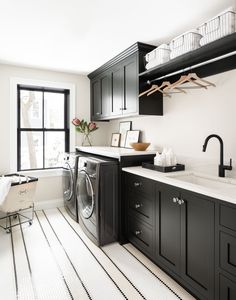 a washer and dryer in a very large room with white tile flooring