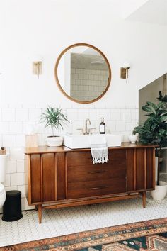 a bathroom with a sink, mirror and rug on the floor in front of it