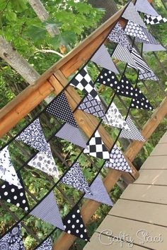 a black and white quilt hanging from a wooden railing