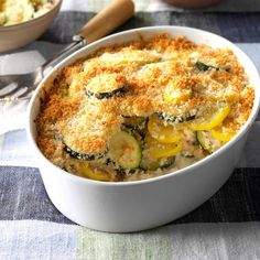 a casserole dish with zucchini, squash and parmesan cheese