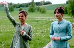 two women standing next to each other in a field