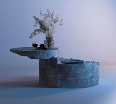 two concrete tables with plants on top and magazines in the middle, against a blue background