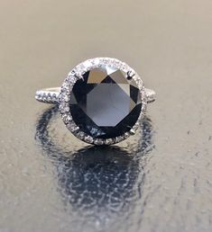 DeKara Designs Collection Metal- 95% Platinum, 5% Iridium. Stones- Genuine Round Black Diamond 6.50 Carats 10.25 MM, 44 Round Diamonds F-G Color VS1-VS2 Clarity 0.28 Carats. Size- 5 3/4. FREE SIZING Beautiful Handmade Platinum Halo Black Diamond Engagement Ring. The beautiful and fiery round black diamond is uniquely cut and is professionally set in between four Eagle Claw prongs. The center black diamond is surrounded by 24 round dazzling diamonds that are meticulously French Pave set, as well Classic Black Spinel Ring For Formal Occasions, Classic Formal Black Spinel Rings, Classic Black Spinel Diamond Ring For Formal Occasions, Timeless Black Jewelry With Center Stone, Classic Formal Black Diamond Ring, Classic Black Diamond Ring For Wedding, Formal Black Diamond Ring With Prong Setting, Black Diamond Ring With Halo Setting For Anniversary, Formal Black Round Cut Rings