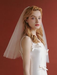 a woman in a white dress with a veil on her head