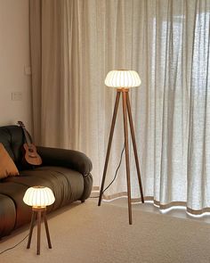 a living room scene with focus on the floor lamp and guitar propped up against the wall