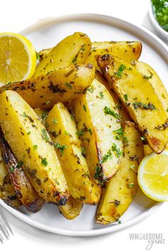 grilled potatoes with lemon and parsley on a white plate, ready to be eaten