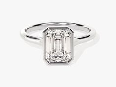 an emerald - cut diamond ring on a white background