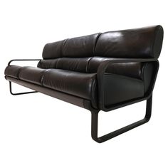 a black leather couch sitting on top of a metal frame