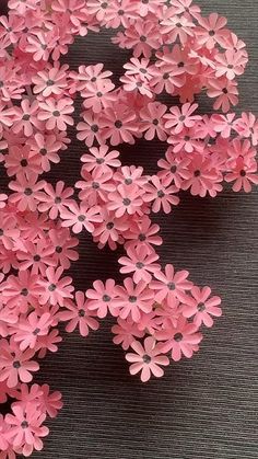 small pink flowers are arranged on the table for decoration or as an art project in this photo