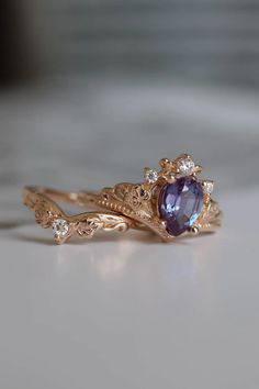 a gold ring with an amethorate and white diamonds on the side, sitting on a table