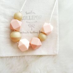 three pink and gold beads on a white cloth