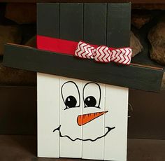 a wooden block with a snowman face painted on it