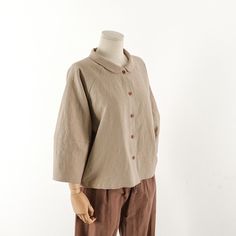 a mannequin wearing a beige shirt and brown pants